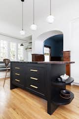 Dyer Studio custom-designed the island with a black-stained white oak wood base and a walnut and soapstone counter that curves at both ends.