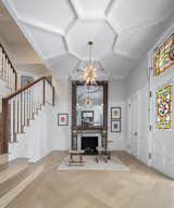 After: The team installed a more appropriately scaled staircase so that the foyer is a proper entry point to the house. The radial ceiling trim accents a new chandelier.