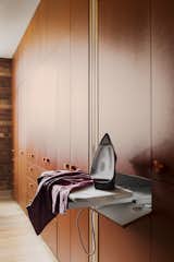 A pull-out ironing board is tucked into the cabinetry.