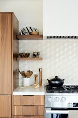 A Heath Ceramics tile backsplash in neutral tones offsets the custom walnut cabinetry.