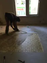 During: Peeling back layers of linoleum to get to the original floor underneath.