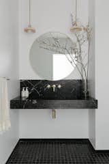 The showpiece in the new bathroom is the floating vanity with an integrated sink carved from a block of Nero Marquina marble.