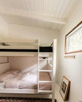 White paint makes the room feel bigger, and a bunk bed with a double-sized mattress on the bottom, utilizes the space more comfortably.