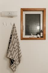A towel from Dusen Dusen hangs from wall hooks from Thing Industries.