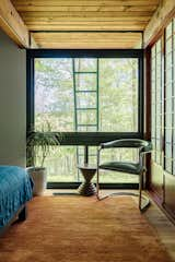 In the bedroom, a vintage Thonet chair sits with a World Market table in front of the new window. Alex added red Shoji-style doors to the closets to honor the home’s "Japanese vibes."