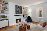 Simple storage and floating shelves flank the fireplace. A Moroso sofa sits with tables from BluDot.