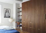 The bespoke walnut storage and brass hardware in the principal bedroom was designed by Tang. The lamp is by Noguchi.