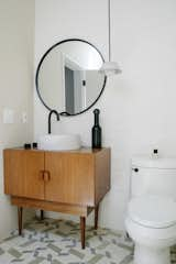 In the bathroom, the floor is covered in custom concrete tile from Mexico. The vanity is a vintage piece topped with a concrete sink basin.