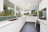The lightly updated kitchen benefits from windows wrapping the room.