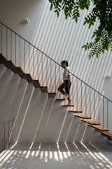 Dappled shadows are cast by the exterior concrete screen and the cantilevered tread at the stairs.