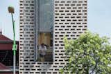 A window breaks up the street-facing facade composed of perforated cement blocks.