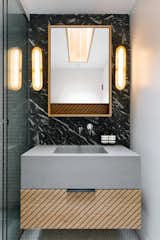 A custom concrete sink is illuminated with sconces from Apparatus Studio.
