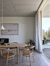 Thonet chairs surround a table from Made by Morgen, and the pendant is by Cult Design. The dining room cedes to an exterior terrace.