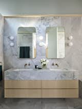 Astra Walker faucets bedeck the vanity. The aged brass and honed marble "further reflect the human interaction with nature and time," says Fox.