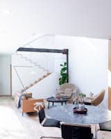 The living room is a double-height volume filled with natural light. The furniture and housewares are by Knoll and Muuto.