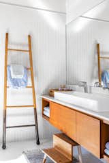 In the kids’ bath, a custom vanity by Christopher Derek Bruno and a ladder by Lostine extend the home’s warm material palette.