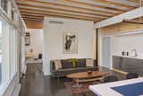 A partition wall separates the living space and kitchen from a small studio.
