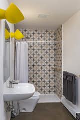 Ali chose a wall tile that reflects the early ’70s era when the building was constructed. The oversized yellow wall lights are from IKEA.