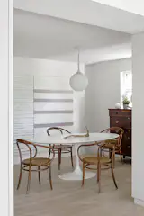 In the new dining room, a Saarinen table is lit by an Artimide Castore pendant that the couple found on the sidewalk.