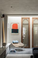 The Meranti wood and glass doors are over nine feet tall, and have a custom arch detail at the top. The clay coating on the walls and ceiling are by Matteo Brioni. “We mixed some colors together to give the space a perfect warm and serene feel,” says Valérie. “We like to add the same clay finish to the ceiling as the walls to create a sense of intimacy.”