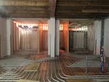 During: This shot shows the new interior walls for the bedrooms and the heating system laid below the concrete floor.