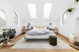 A bed from BluDot is flanked by white oak nightstands designed and built by Jason, and Cedar and Moss wall sconces. New skylights and windows bring in much-needed light.