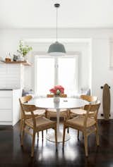 A tulip table with a honed marble Carrara top (from DWR) is surrounded by Carl Hansen ch23 Hans Wagner chairs.