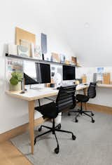 Jason custom made the shared desk with white oak legs and a plywood and laminate top. The chairs are a limited edition all-black finish from Laura Davidson, and the shelves are from Shelfology.