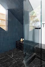 The shower has concrete tile from Zia Tile which was painstakingly cut to follow the angle of the ceiling. The exterior wood screen provides privacy over the windows while allowing light in.
