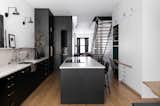 Storage had to be dialed in within the narrow footprint of the brownstone. The black core holds the pantry, while on the right, a bank of custom cabinetry hosts the command station, mop closet, and a concealed bar.-