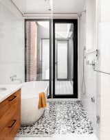 After: The floor of the bath and shower area is clad in Krista Watterworth Kiss Marble tiles, and the exterior door can be opened so the owners can bathe al fresco.