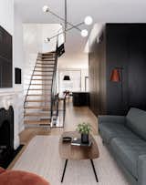 The black core anchors the home and tucks utilitarian functions behind imperceptible doors. The core “connects the floors visually, enhances the verticality of the townhouse, and creates a dramatic backdrop for the hallway bridges at each level,” notes the firm.
