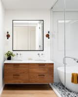 Cedar &amp; Moss sconces illuminate the vanity, which has Kohler sinks and Watermark faucets.