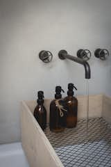 A plywood box with a mesh bottom holds bottles and allows the water to pour through.