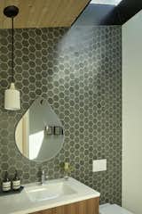 In the kids’ bath, green hexagon tile from Heath Ceramics is a lovely backdrop for the walnut vanity.