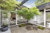 The owners planted a Japanese moss garden accented by crushed granite, as well as a lace leaf maple, which turns red during fall. Mature black bamboo grows through the open ceiling from its freestanding pot.