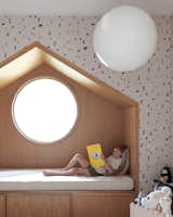 In a spare bedroom/playroom located in another section of the house, Berg played with juxtapositions of shapes, installing an oak-wrapped, triangular reading nook inset with a circular window.