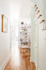 An existing hallway runs from the entry, through a “reading room,” to the kitchen. The curved door under the stairs was kept.