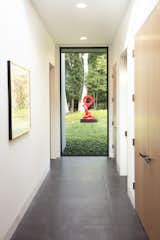 A fixed window at the end of a hallway frames an outdoor sculpture. The acoustics throughout the home are comfortable, says Kurth, thanks to a high-level of insulation and tight envelope. "There's no echo-y sound," says Kurth.