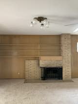 Before: The family room had a brick fireplace, paneling, and carpet.