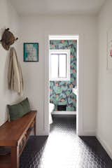 Black hex floor tile from Wayfair runs seamlessly from the mudroom/laundry room and into the powder room.