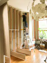 During: Karvelius setting up the new storage piece. The main challenge of the installation was the sloping floors and walls of the old building.
