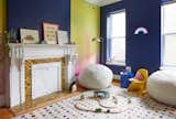 Walls painted ‘Bold Blue’ by Benjamin Moore are joined with the rainbow-hued wallpaper. The rug is from NuLoom.