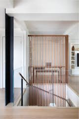 The architects replaced the solid walls with glass for porosity, and exposed a steel structural column. The main entry is to the left of the stairs. A walnut slat wall lines the staircase, with the slats plunging down to the lower level for definition and to ensure light could flow.