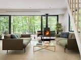 The windows and doors are by Solar Innovations, with pale wood flooring by Sawyer Mason, a Wittus fireplace, and Muuto sofas.