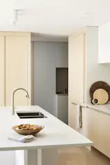 The full-height ash cabinetry in the kitchen earmarks the entry into the new mudroom and pantry, the latter which is to the left around the corner.