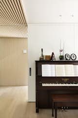 The slatted millwork continues so as to frame the threshold between the entry and the main spaces.