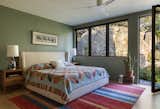 The primary bedroom windows frame up-close views of the boulders on the site.