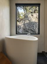A Japanese soaking tub is positioned beneath a window to appreciate the site.