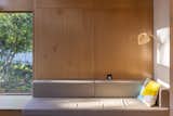 A built-in couch sits against birch plywood walls.